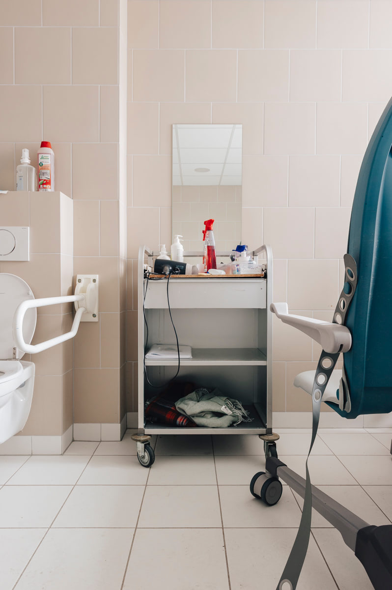 Verzorgingskar met spiegel in de gemeenschappelijke badkamer vóór de herinrichting