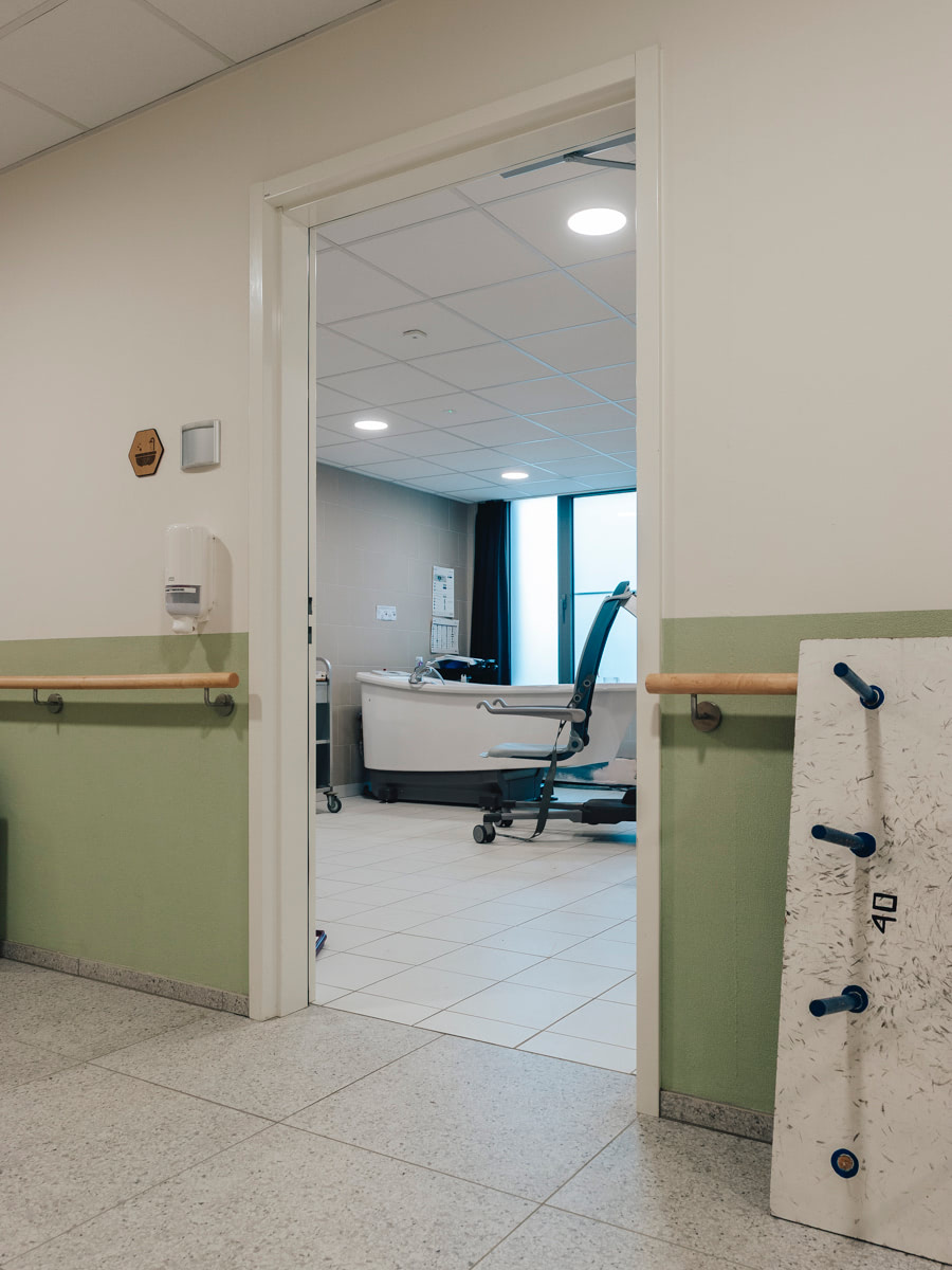 Zicht vanuit de gang op de badkamer met hoog-laagbad in WZC Mariaburcht