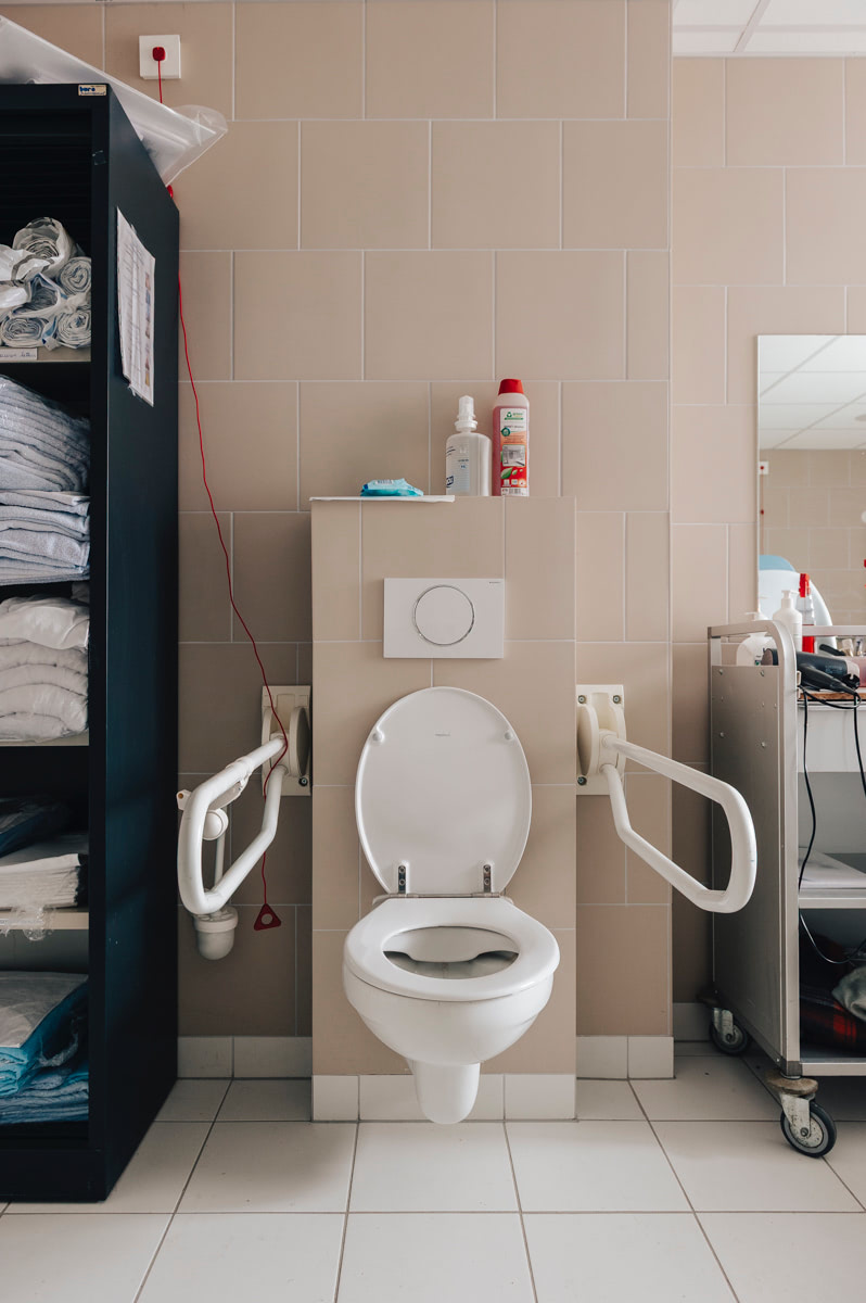 Toilet met steunbeugels in de gemeenschappelijke badkamer van WZC Mariaburcht