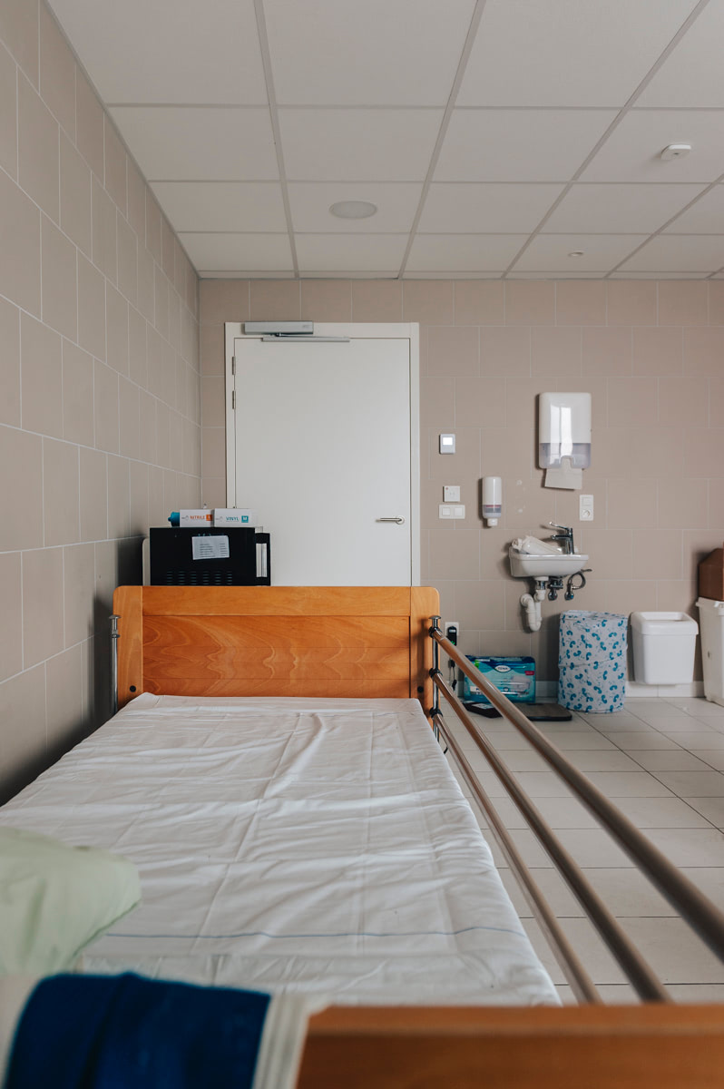 Rustbed met magnetron en wastafel in de gemeenschappelijke badkamer vóór de herinrichting