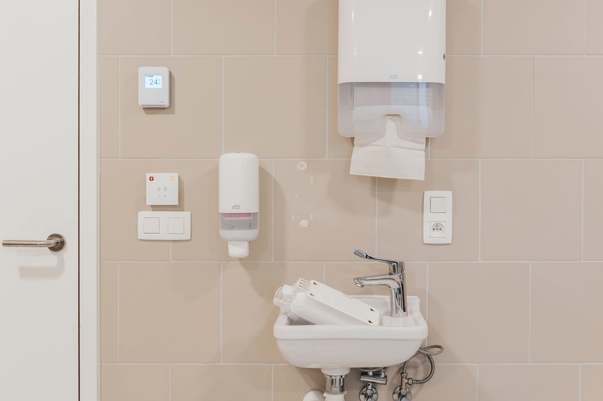 Wastafel met zeep- en handdoekdispensers in de badkamer