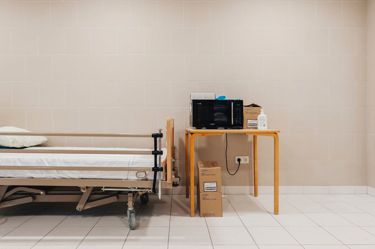 Verzorgingsbed en tafeltje met magnetron in de gemeenschappelijke badkamer