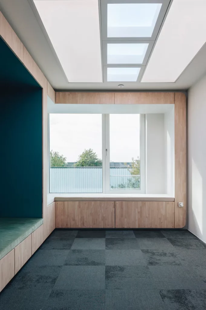 Wachtruimte met daglicht via het plafond, raambank en houten kastenwand