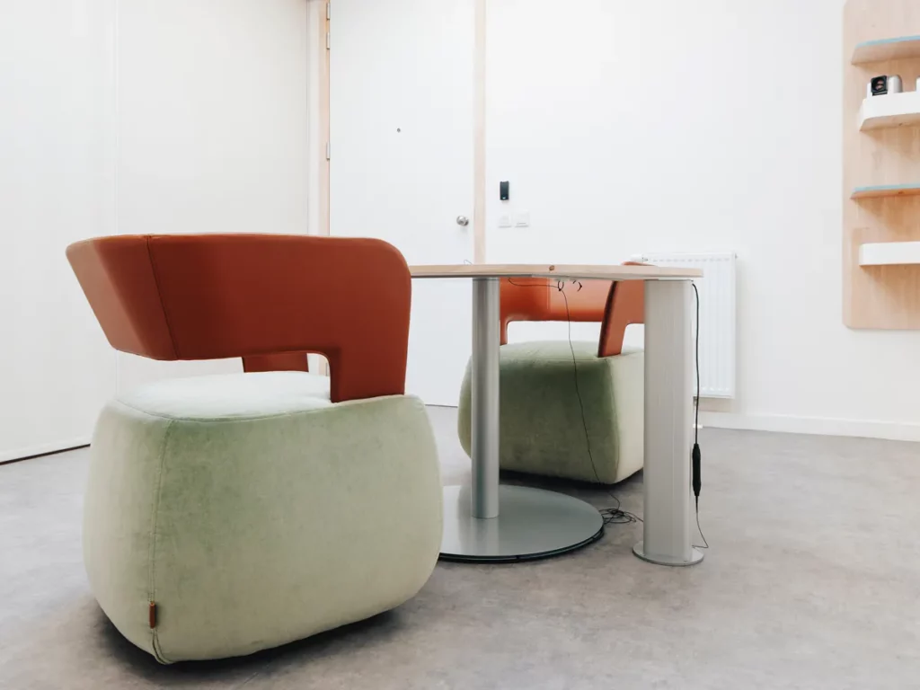 Twee zachte fauteuils aan de ronde tafel in de videoverhoorkamer